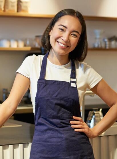 Cafe worker with hand on hip smiling at camera