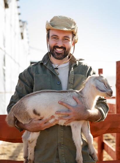 Man holding goat smiling